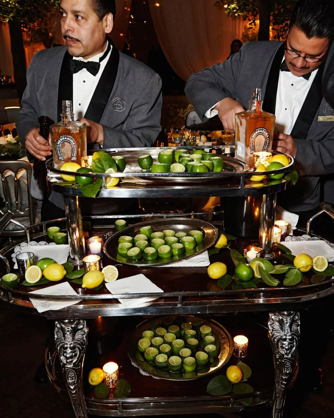 Bartenders preparing cocktails with fresh citrus at a busy bar