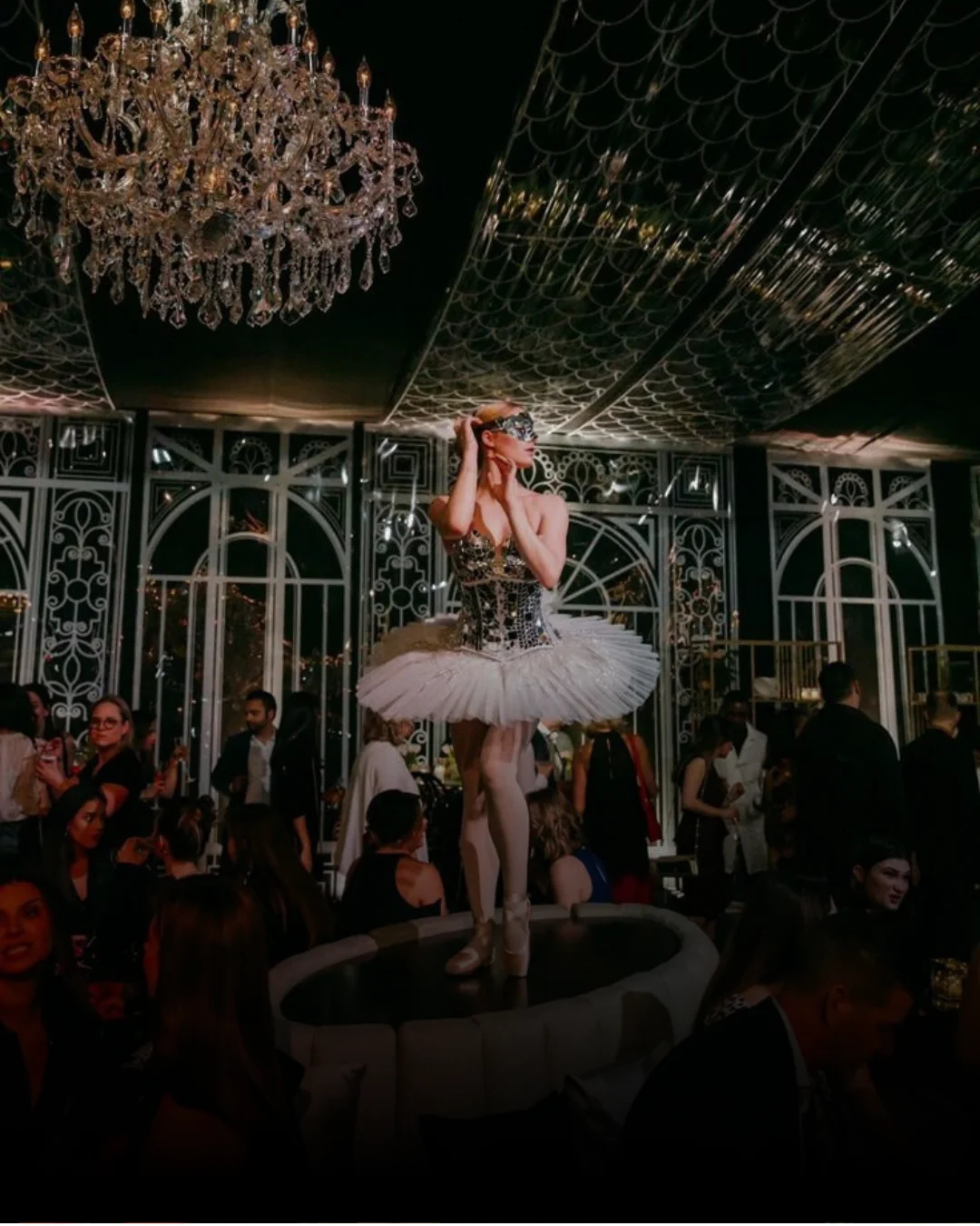 A dancer performing beneath a chandelier in a garden-inspired dining room